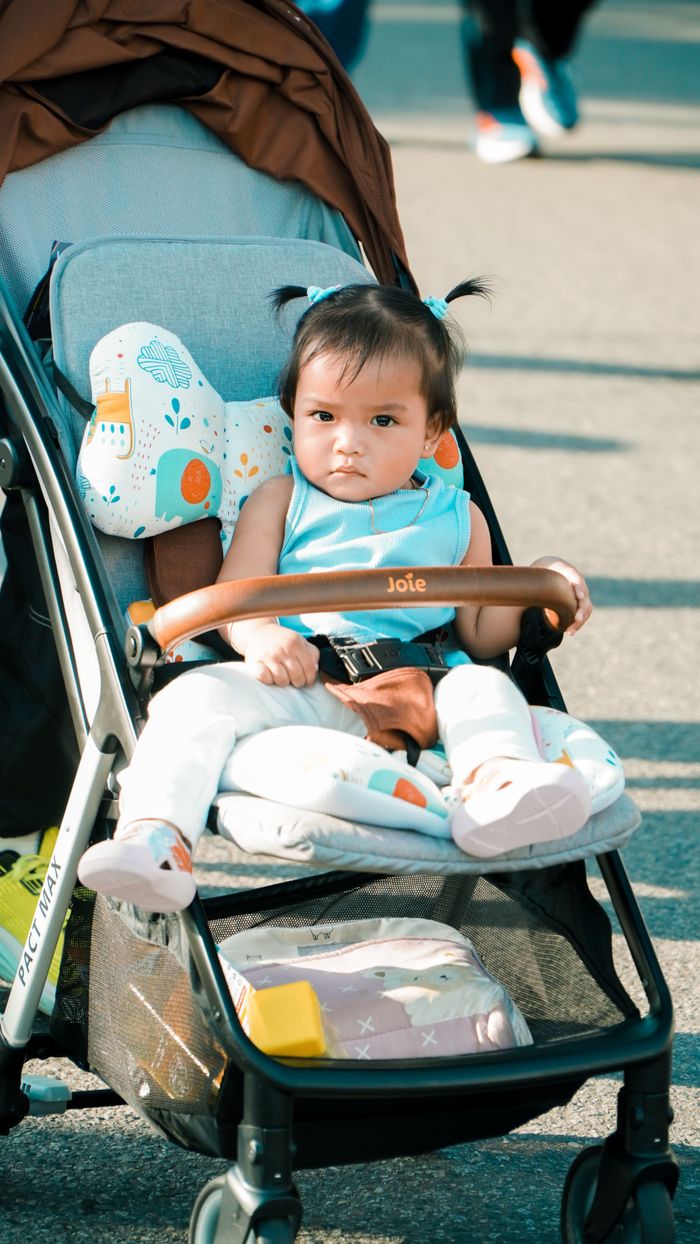 Contact Cute baby sitting in a stroller during a sunny day in Pontianak's car-free event.